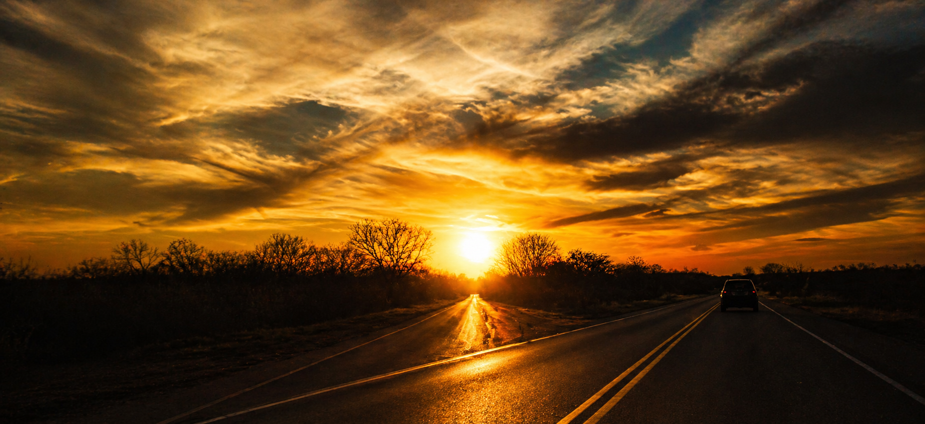 Estrada ao pôr do sol com céu dourado e dramático